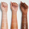 Three arms displaying all SHEGLAM Skinfinite Foundation shades from light to deep tones.