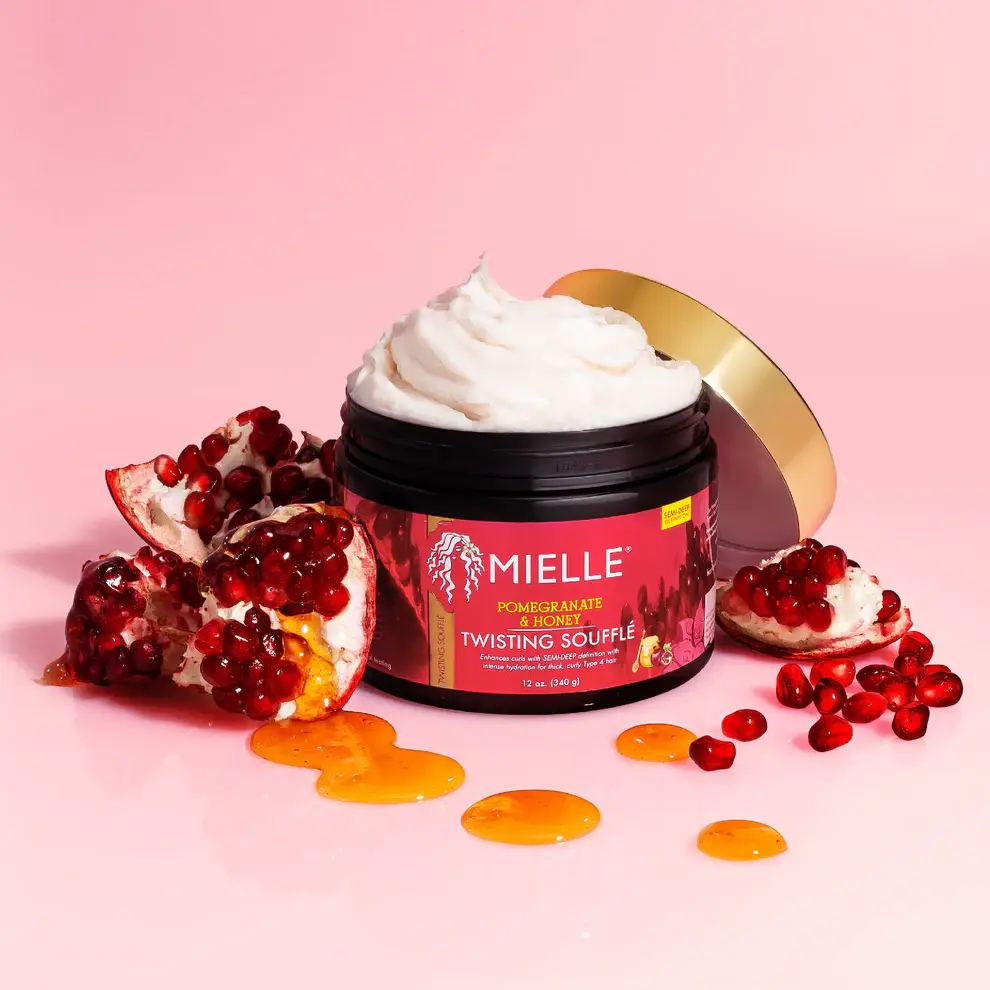 Open jar of Mielle Twisting Soufflé with creamy texture, honey drizzle, and fresh pomegranate seeds