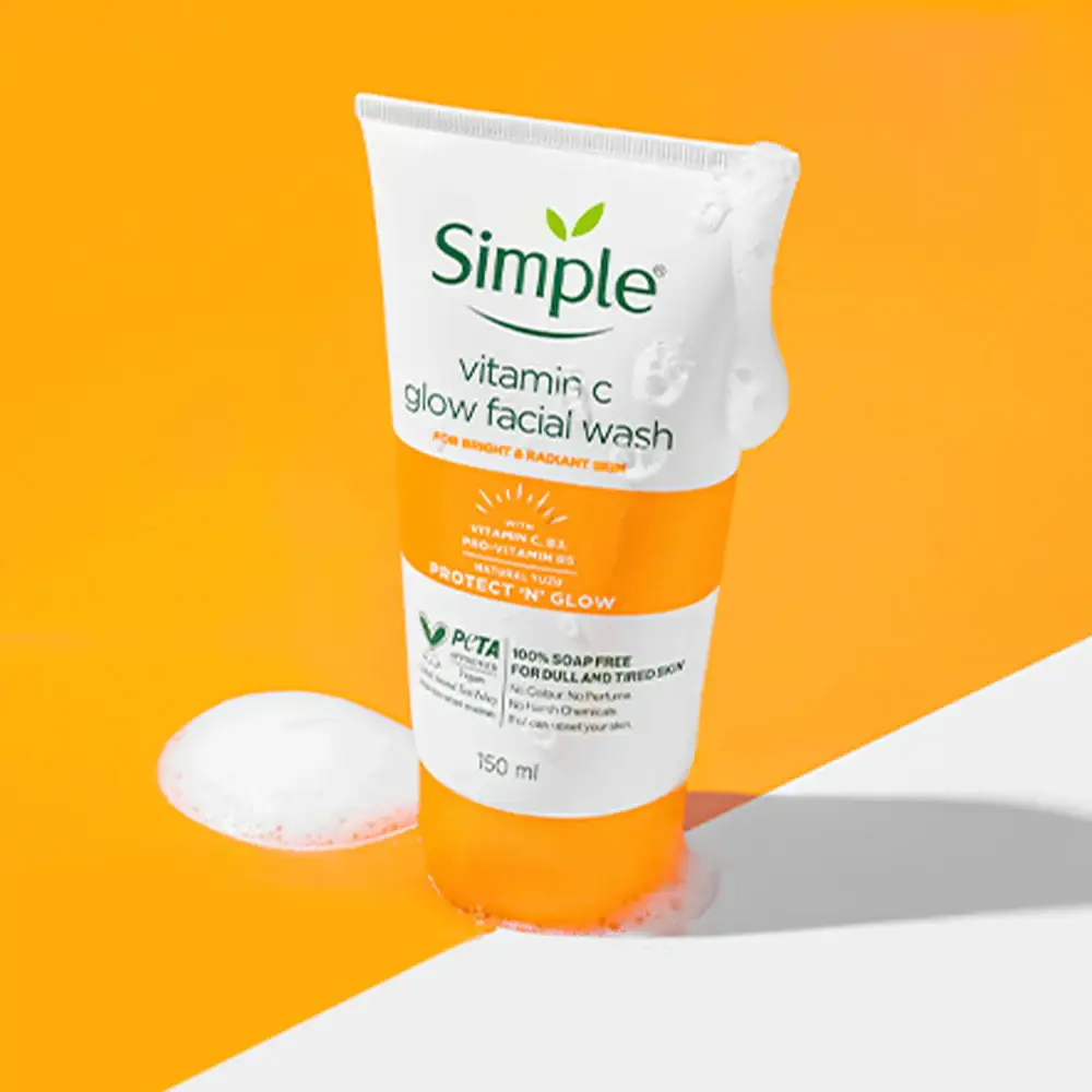 Simple Vitamin C Glow Facial Wash with foam on vibrant orange background